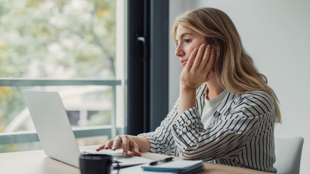 Tired woman working at a laptop, illustrating high-functioning depression