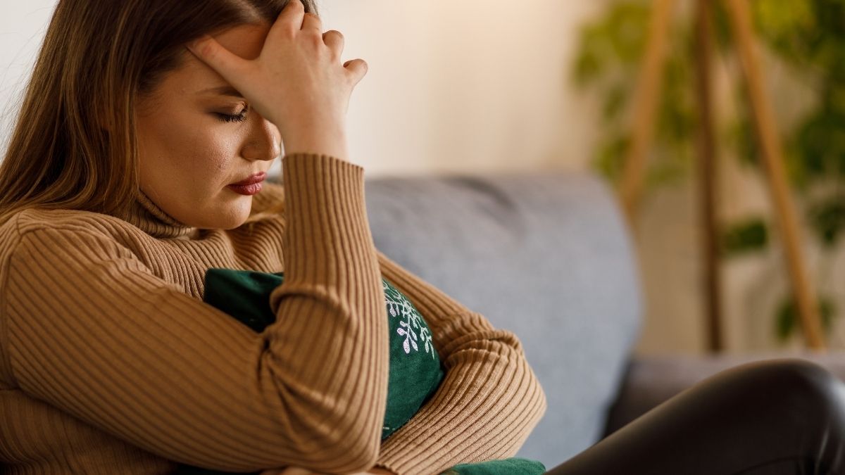 Distressed woman holding her head, experiencing intrusive thoughts