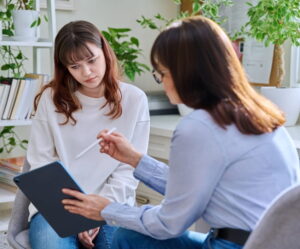Therapist and client reviewing a plan on a tablet before beginning DBT sessions