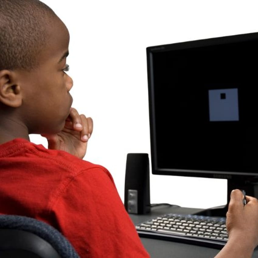Child taking the computerized T.O.V.A. attention test and pressing the microswitch
