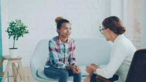 Young woman talking with her therapist during a first therapy session