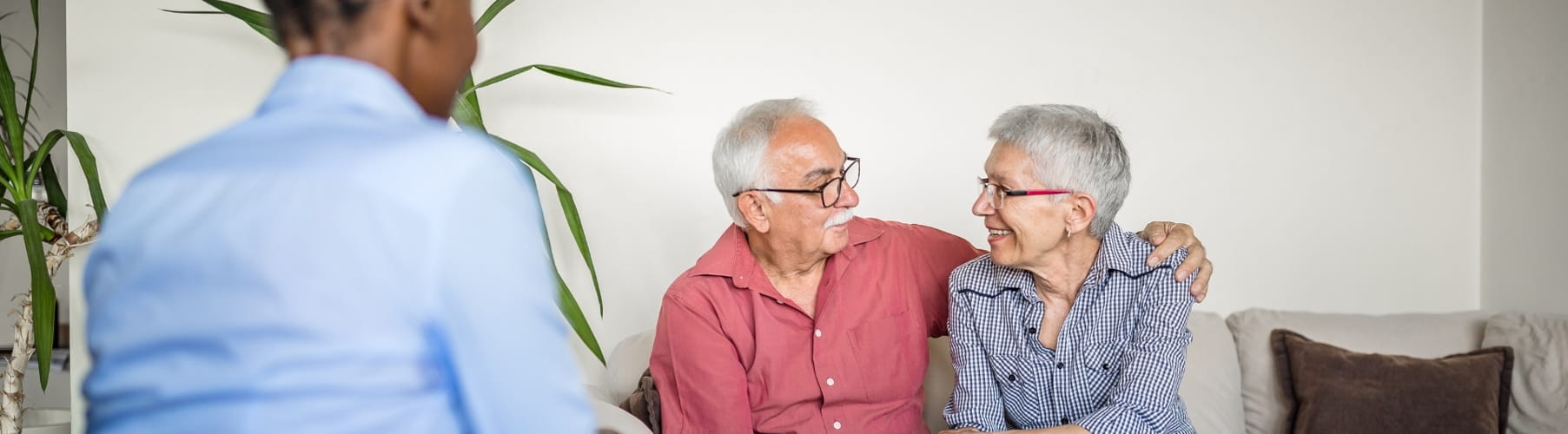 Older couple sitting close on a sofa, smiling at each other during a therapy session in Vaughan