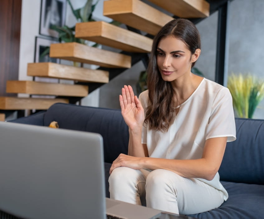 Woman waving as a free half-hour therapy consultation begins over video