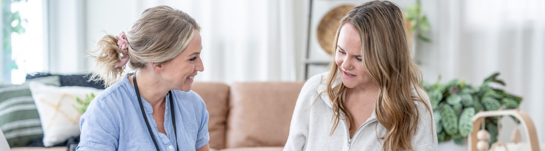 Therapist talking with a new mother during a postpartum therapy session