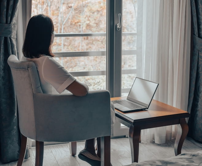 Woman with seasonal depression sitting alone by a window in winter