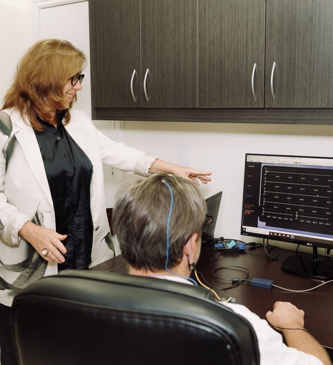 Clinician placing an EEG sensor before a neurofeedback session