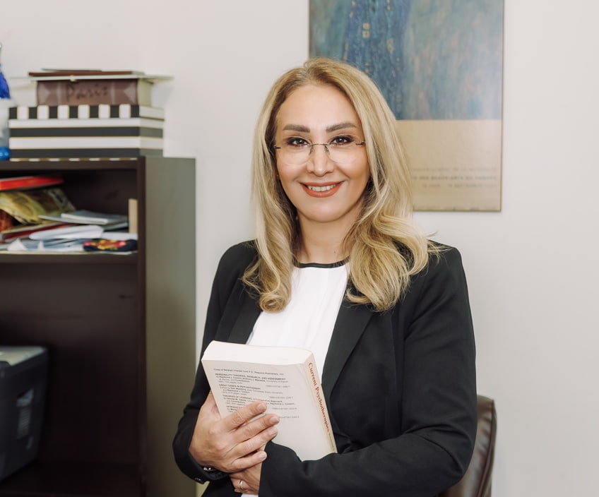 Therapist at a Vaughan psychotherapy clinic holding a textbook on current psychotherapies